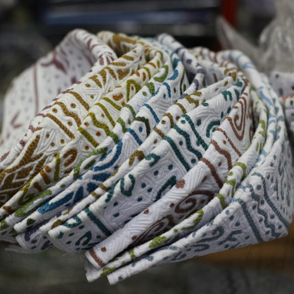 كمم عُمانية بيضاء مطرّزة بخيوط ملوّنة